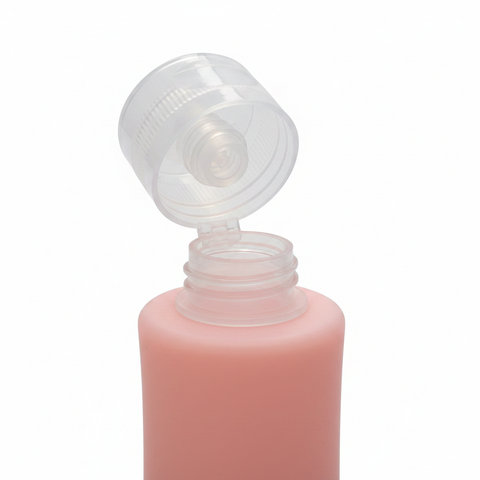 Close-up detail of pink silicone travel bottle cap and opening on white background