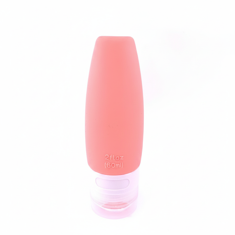 Coral pink silicone travel squeeze bottle 60ml standing upright on pure white background – main product image