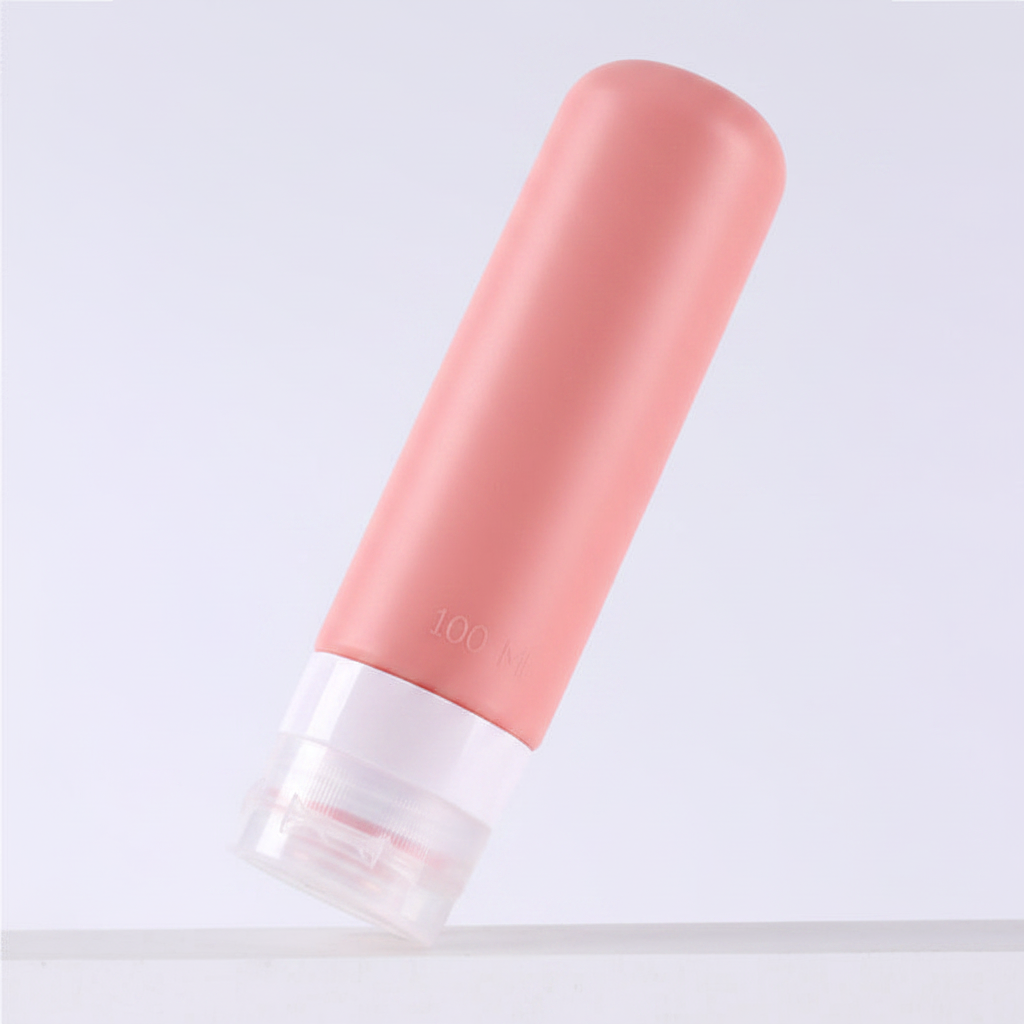 Dusty rose pink silicone travel bottle 100ml at 45 degree angle showing smooth cylindrical body and clear bottom cap on white background