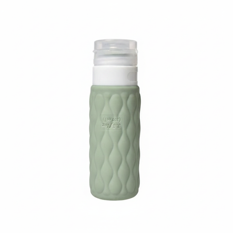 Sage green diamond textured silicone travel cosmetic bottle with white pump cap upright on pure white background – main product image